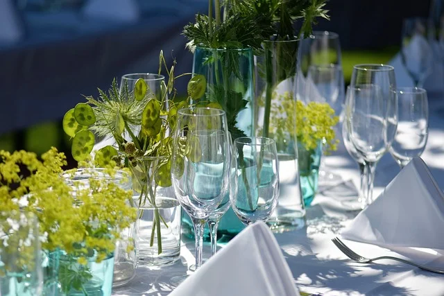 Letnie przyjęcie plenerowe w ogrodzie z nakrytymi stołami i lampionami – aperitif weselny