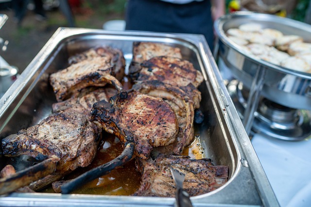 Pojemniki chafing dish z goracym miesem na weselnym bufecie plenerowym